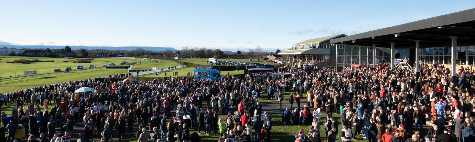 A large crowd at Hereford Racecourse looks out over the race track
