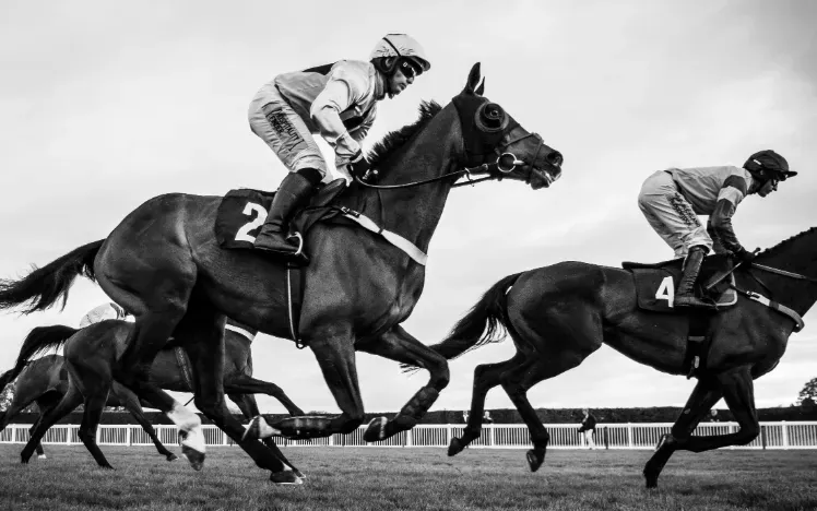 A black and white image of horses racing at Hereford racecourse