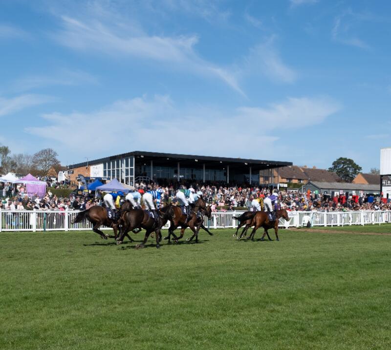 Horses racing past some of the crowds at Hereford Races