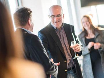 Two gentlemen shaking hands at a conference.
